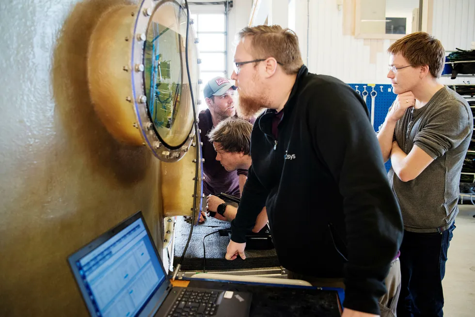 Bjørn Folkvord Esaiassen ser inn i en vanntank under test av en undervannsrobot hos Icsys på Klepp. Bak fra venstre Thomas Aunvik, Sven Hatteland og Vidar Haus.