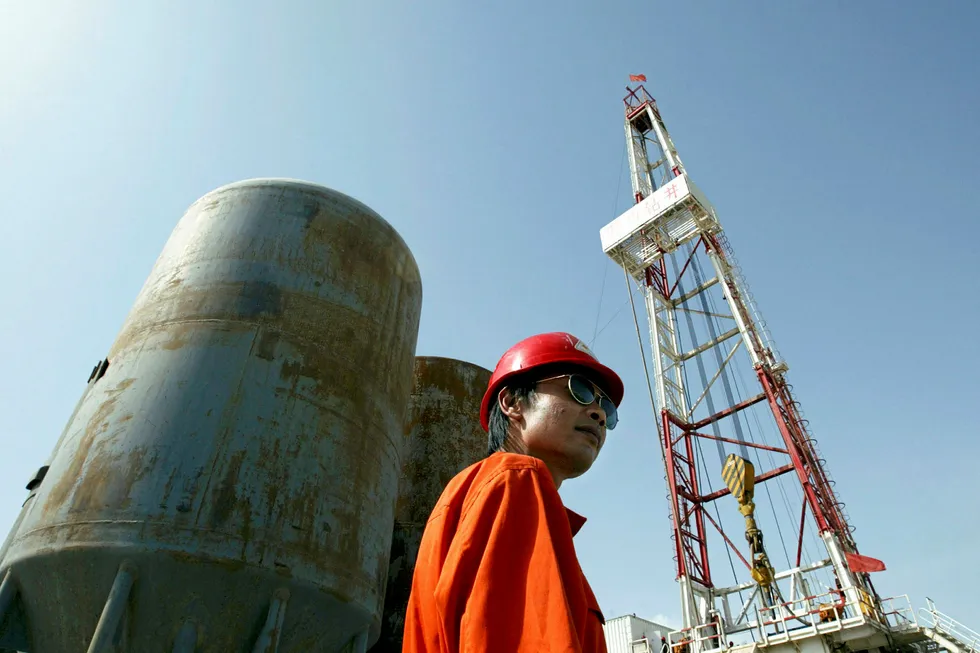 Investment efforts: a worker at an oil drilling operation in the Tarim basin