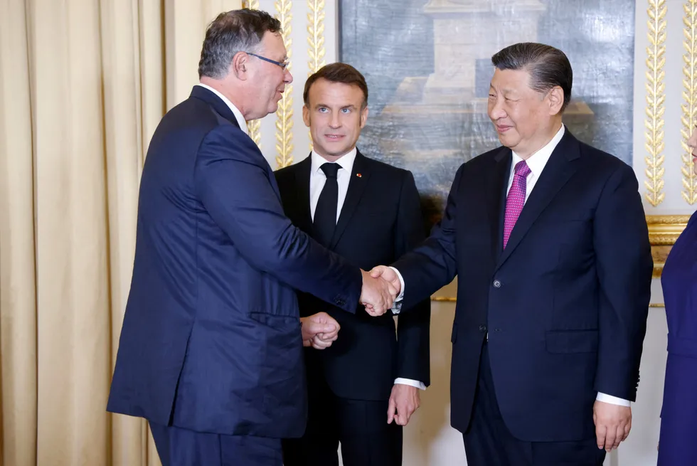 TotalEnergies chief executive Patrick Pouyanne (left) shakes hands with Chinese President Xi Jinping (right) in the presence of France's President Emmanuel Macron.
