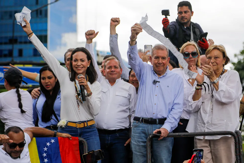 Opposisjonslederne Maria Corina Machado og Edmundo Gonzalez løfter dokumenter med valgresultater i en demonstrasjon Carcas, Venezuela på tirsdag.