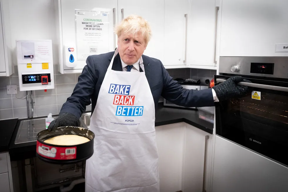 Storbritannias statsminister Boris Johnson prøver seg på baking i Manchester. Flere briter sliter nå med å få tak i både drivstoff og dagligvarer.