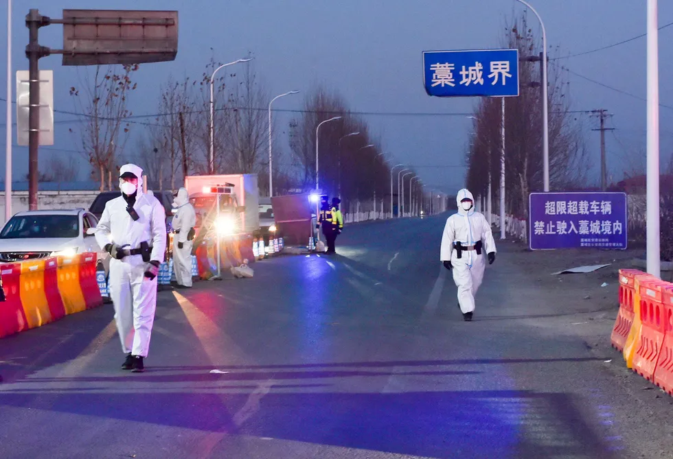 Rising cases: police officers and staff members in protective suits inspect vehicles at a checkpoint on the borders of Gaocheng district on a provincial highway, following the Covid-19 outbreak in Hebei province