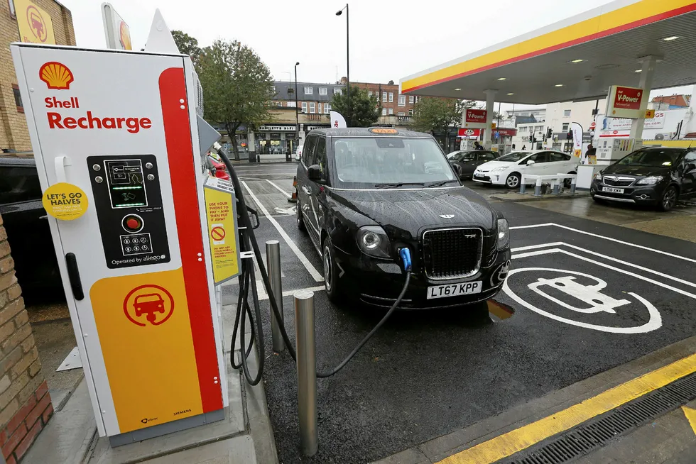 Electric cars growth: A London taxi is plugged into a charging station.