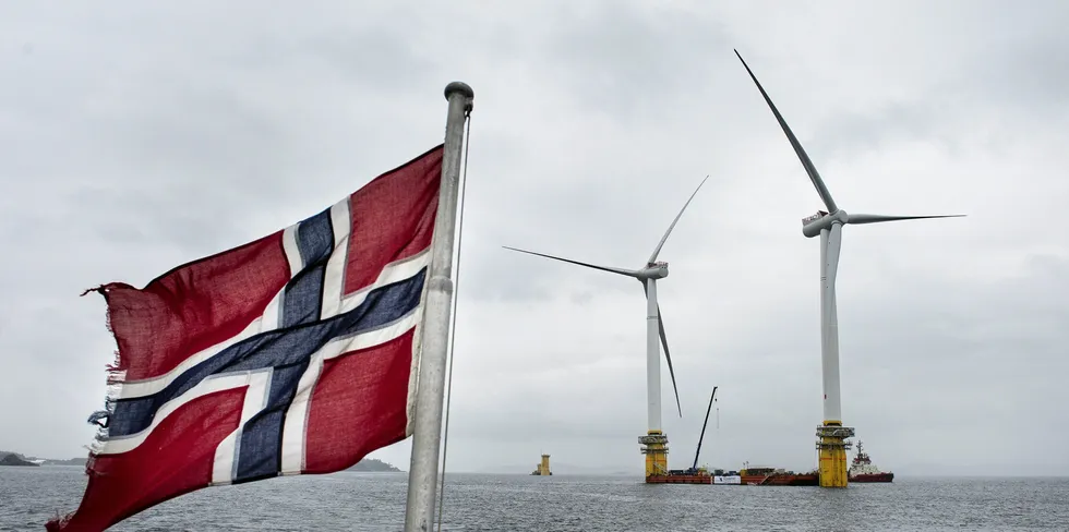 A Norwegian flag flies from a boat near the assembly site of floating wind units for Equinor's Hywind Scotland project - the world's first full-scale array - in 2017