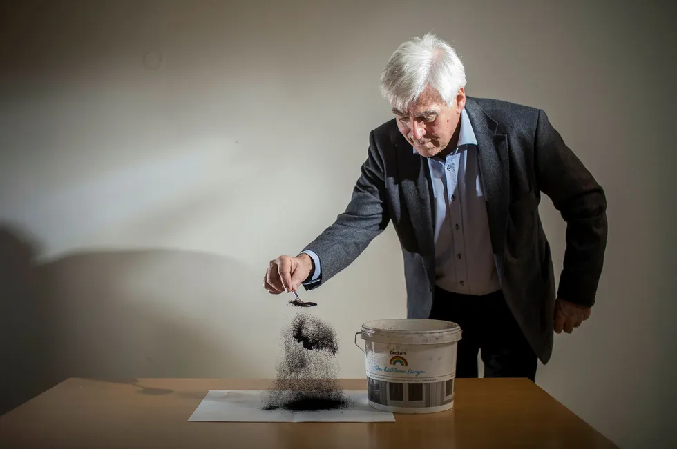 Arne Godal strør en skje karbonpulver på et ark. Salgbart, rent karbon skal nå være et biprodukt av hydrogenproduksjonen. Hans tidligere karbon prosjekt Carbontech gikk konkurs. Foto: Eivind Senneset