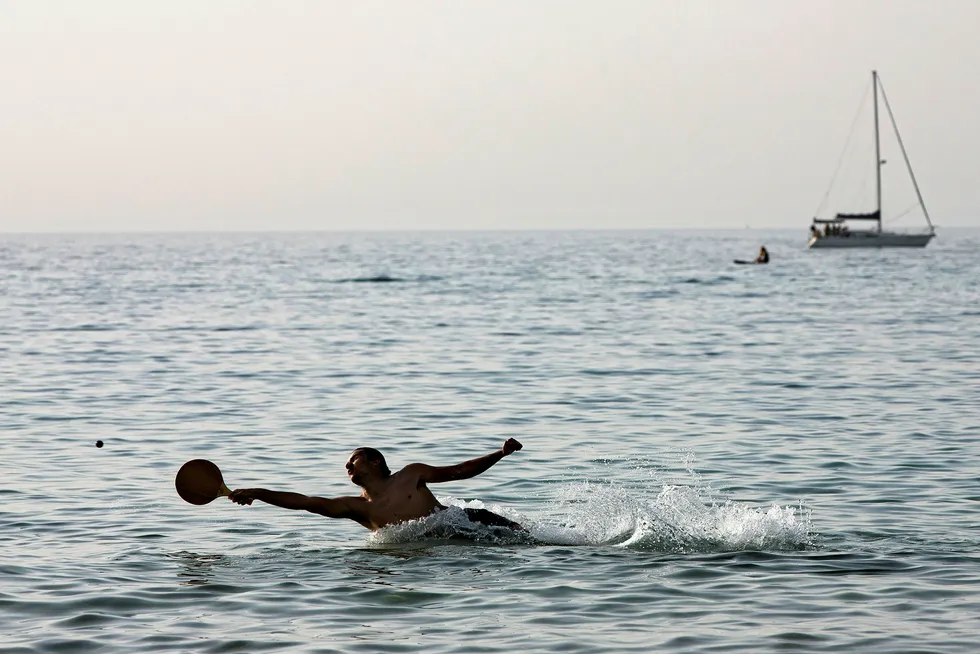 Recreation: a man plays paddleball in the Mediterranean Sea off Tel Aviv, Israel