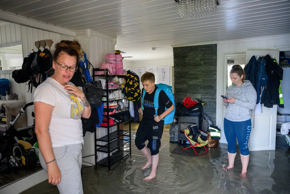 Jeanett Koch Guhaugen (til venstre) og sønnen Lenni Kvamme har fått huset fullt av vann. – Her går det ikke an å bo lenger, sier Guhaugen. Venninnen Karina Husum Storhaug er kommet for å hjelpe til.