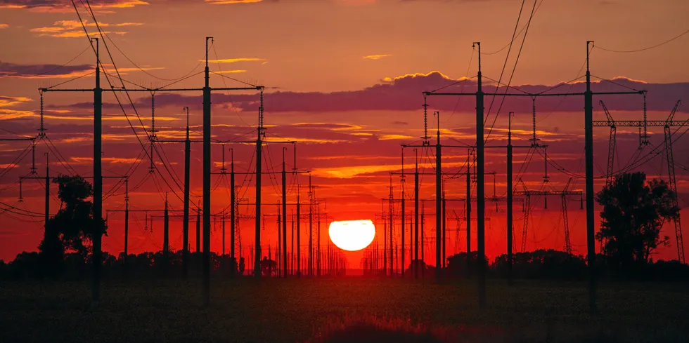 Sunset above high voltage power lines and electricity pylons.