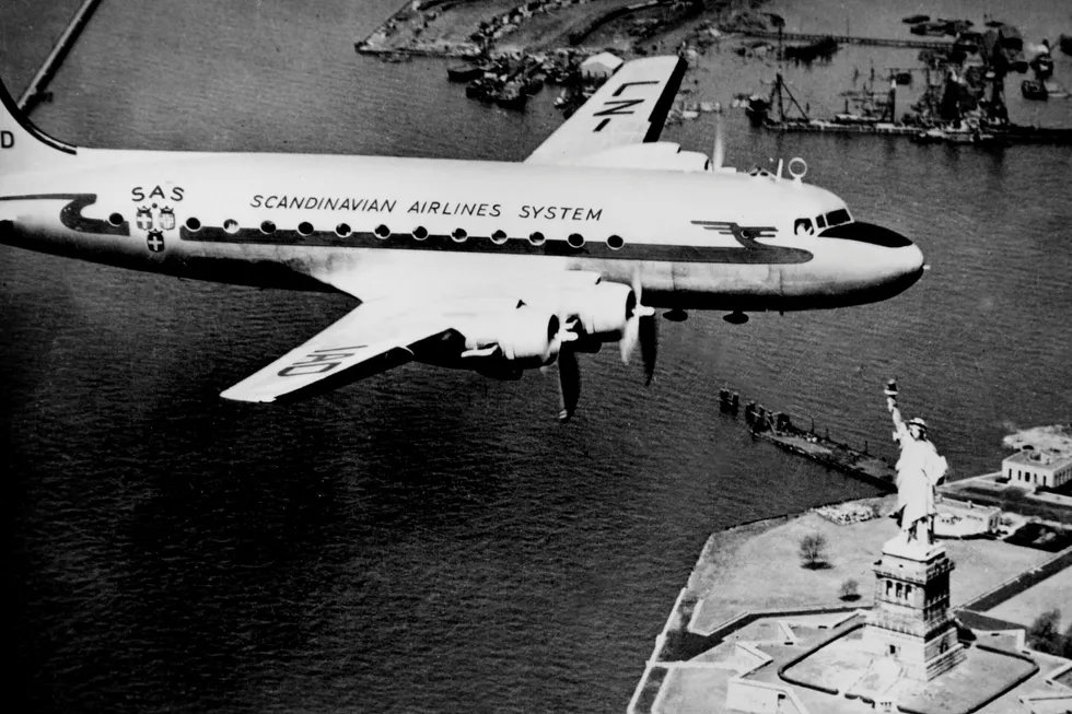 1946: SAS – Scandinavian Airlines Systems – første flyvning over Atlanteren til USA. På bildet passerer flyet, et DC 4, New Yorks kjente landemerke Frihetsgudinnen. Foto: Scanpix Sverige/NTB Scanpix