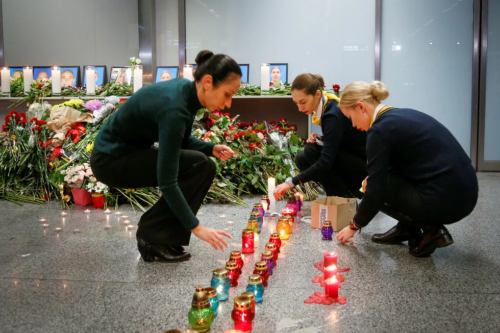 Kolleger av crewet på Ukraine International Airlines tenner lys og legger ned blomster på flyplassen Borispil utenfor Kiev.