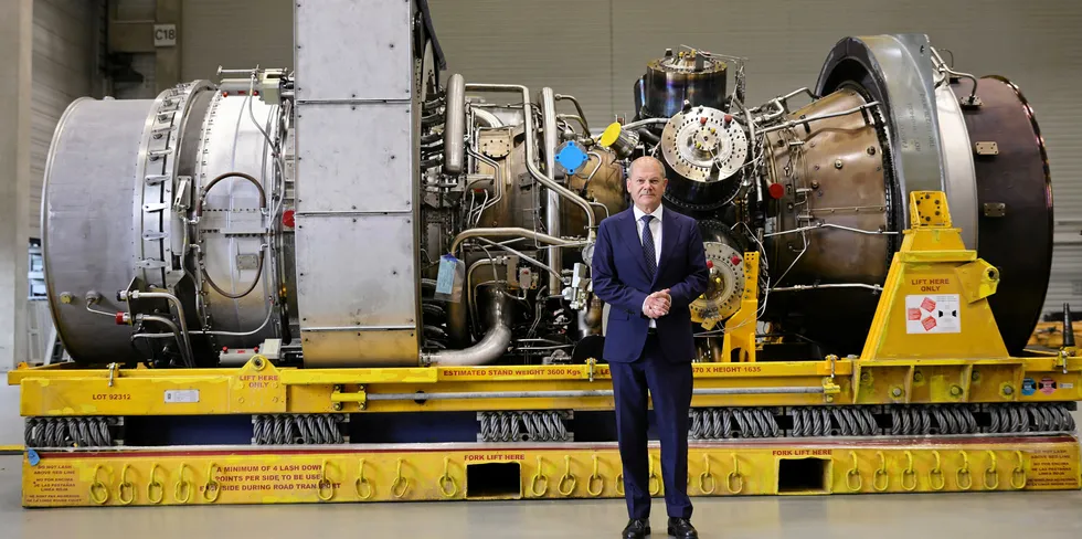 German Chancellor Olaf Scholz in front of a Siemens Energy gas turbine needed for the Nord Stream 1 pipeline