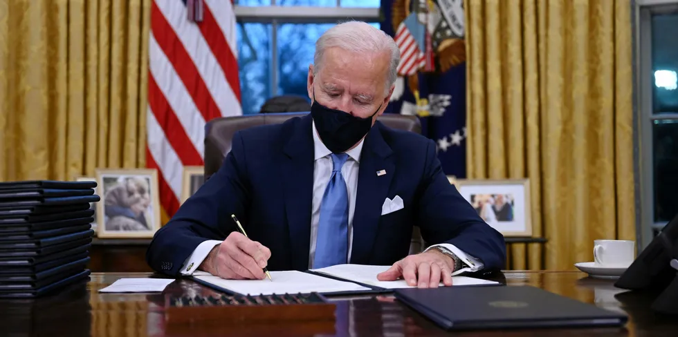 US President Joe Biden sits in the Oval Office as he signs a series of orders at the White House in Washington, DC, after being sworn in at the US Capitol on January 20, 2021.