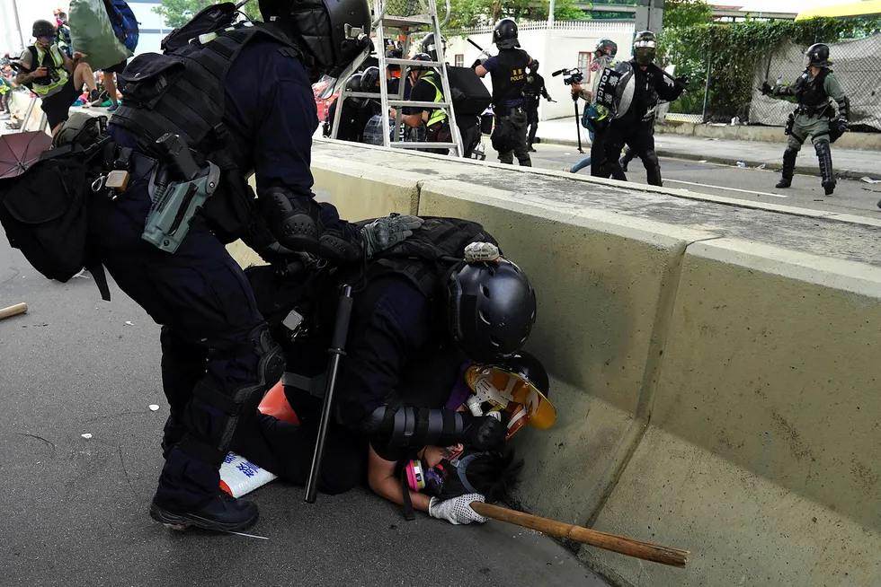 En mann blir lagt i bakken av politiet under demonstrasjonene i Hongkong lørdag.
