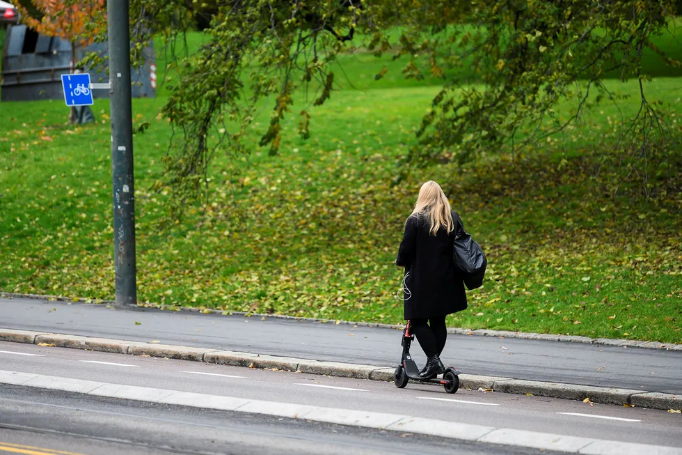 Ung dame på vei opp Henrik Ibsens gate på elektrisk sparkesykkel.