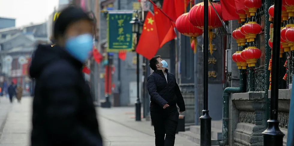 Kinesiske borgere bruker beskyttende masker på en handlegate i Beijing under koronavirusutbruddet, forrige måned.