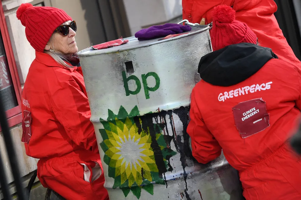 Carrying the can: Greenpeace activists chained themselves to oil barrels during a protest last year outside BP’s London headquarters