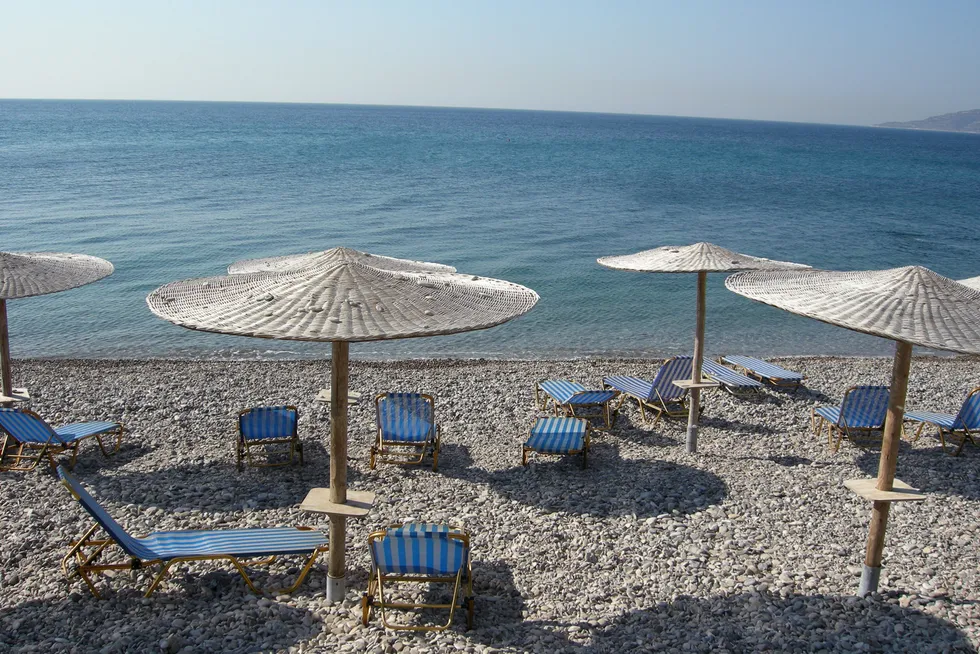 Detur har begjært seg selv konkurs. Tomme solsenger på en strand i Chios, Hellas.