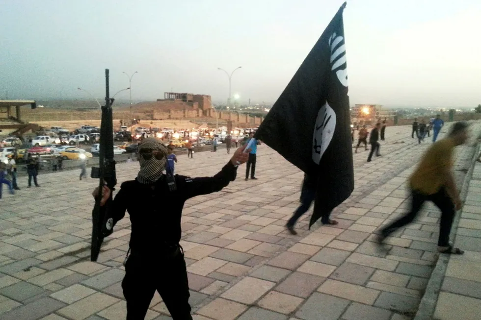 FILE PHOTO: A fighter of the Islamic State of Iraq and the Levant (ISIL) holds an ISIL flag and a weapon on a street in the city of Mosul June 23, 2014. REUTERS/Stringer/File Photo Foto: Stringer .