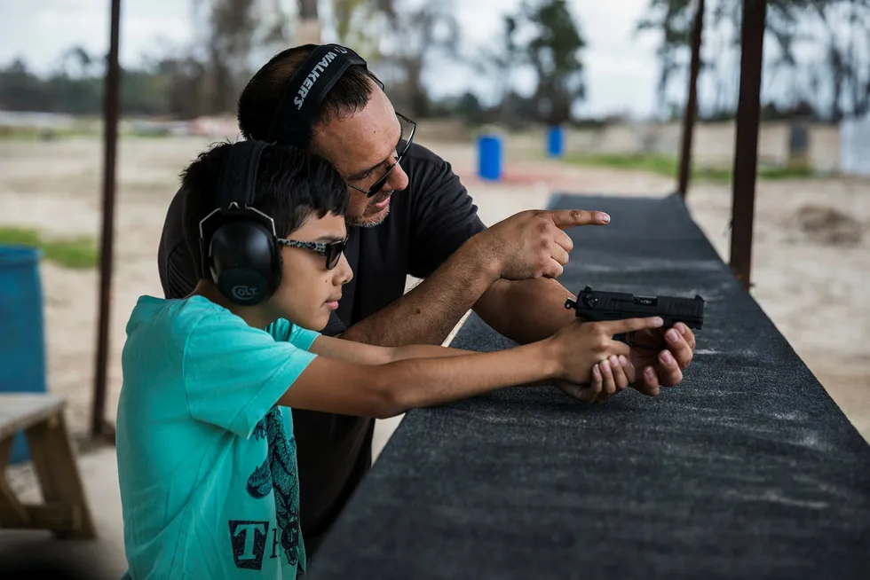 Elizar Flores lærer opp sønnen på ti år til å bruke et håndvåpen med magasin på en skytebane i Houston. Texas er én av statene der våpenlover kan bli avgjørende tema i høstens mellomvalg i USA. Foto: Per Thrana