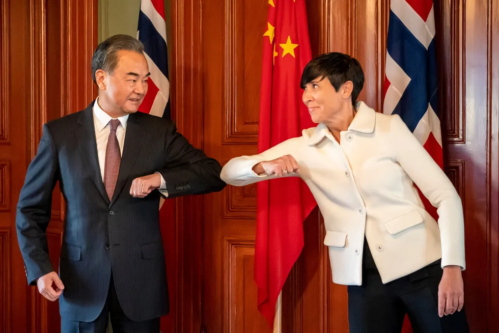 Kinas utenriksminister Wang Yi gjør en korona-hilsen med utenriksminister Ine Eriksen Søreide under en kort visitt i Norge i august i fjor.
