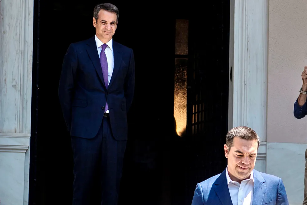 Greece's new conservative Prime Minister Kyriakos Mitsotakis (L) watches his predecessor Alexis Tsipras leaving the Maximos Mansion after their meeting, after being sworn-in on July 8, 2019 following a sweeping election victory put him in charge of the EU's most indebted member with promises to end a decade of economic crisis. - The 51-year-old Harvard graduate and former McKinsey consultant took the oath of office in the presidential mansion in the presence of his wife and three children. (Photo by ANGELOS TZORTZINIS / AFP) ---