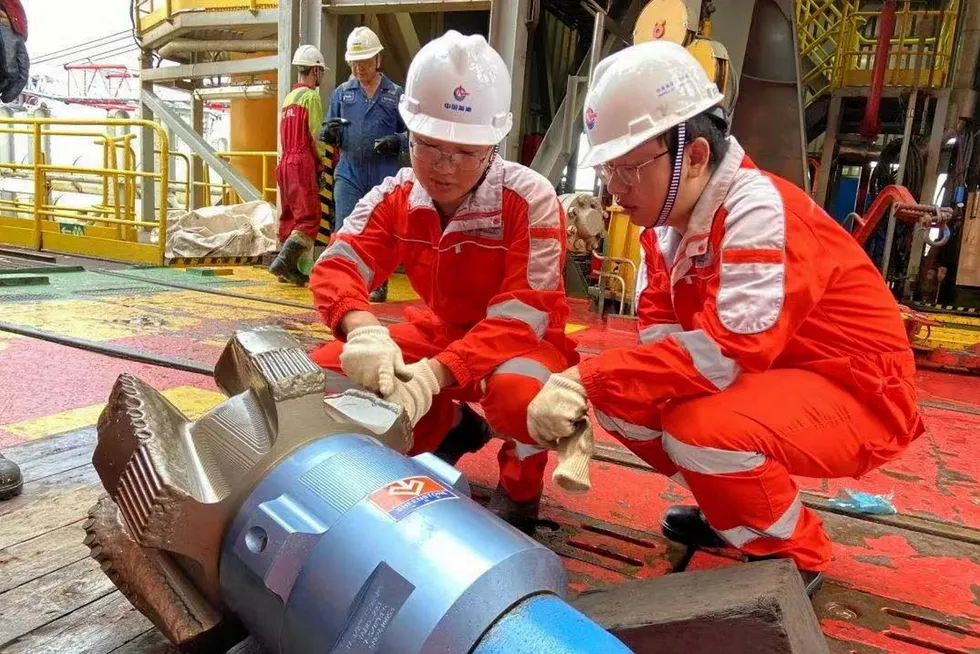 Oil workers: examine the drillbit for CNOOC Ltd’s South China Sea ultra-deepwater drilling campaign.