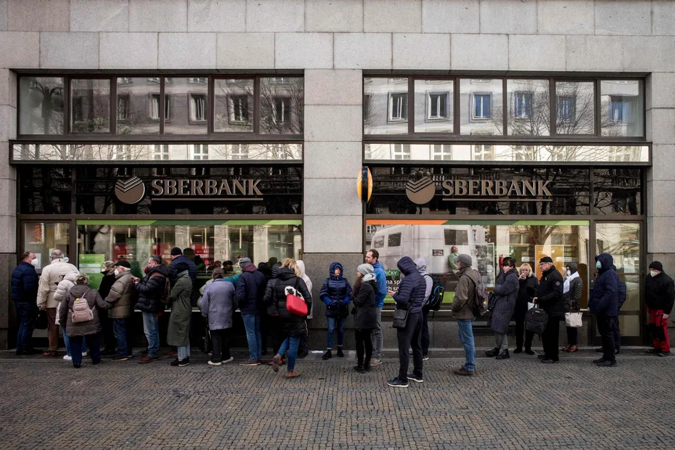 Queue: people wait outside a branch of Russian state-owned bank Sberbank to withdraw their savings and close their accounts in Prague before Sberbank closed all its branches in the Czech Republic
