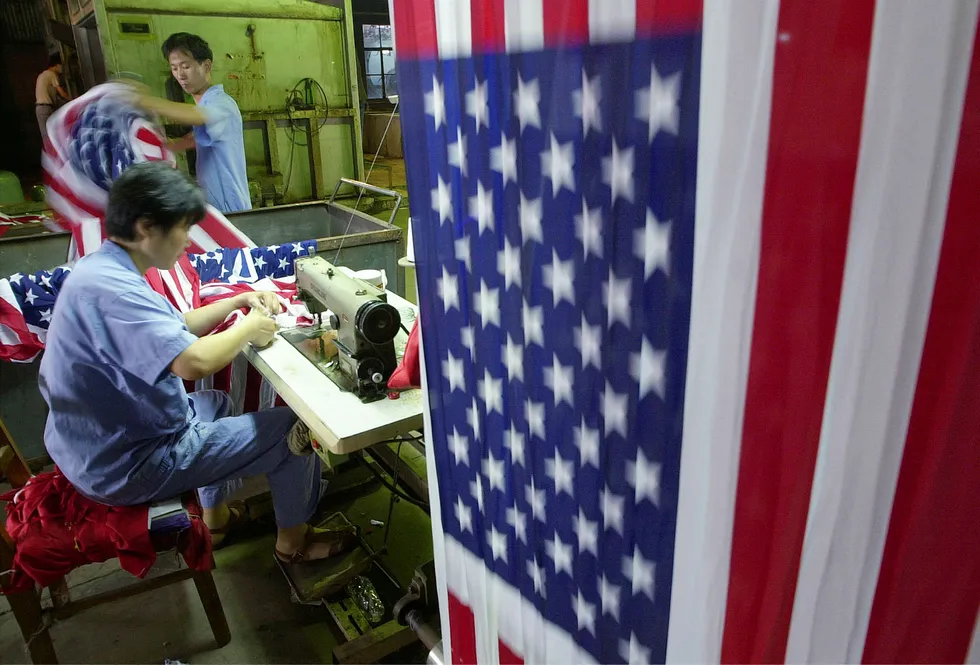 Stadig flere amerikanske selskaper føler seg mindre velkommen i Kina enn tidligere eller vurderer å flytte deler virksomheten andre steder. Bildet er fra en flaggprodusent i Shanghai. Foto: Eugene Hoshiko/AP photo/NTB scanpix