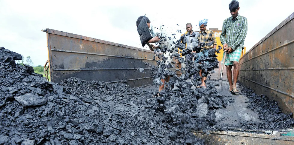 Indian labourers unload coal at a coal field on the outskirts of Hyderabad.