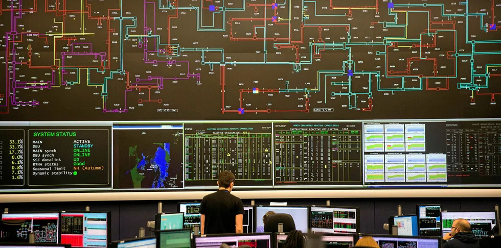 An employee looks at electricity output and usage data on a screen at the National Grid control centre in Wokingham, UK