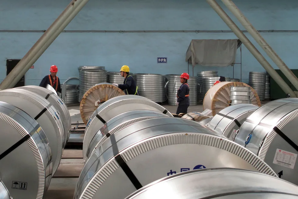 Stålarbeidere pakker nedkjølte ruller med stålwire i Zhangjiagang i Kina. Foto: Muyu Xu / NTB Scanpix