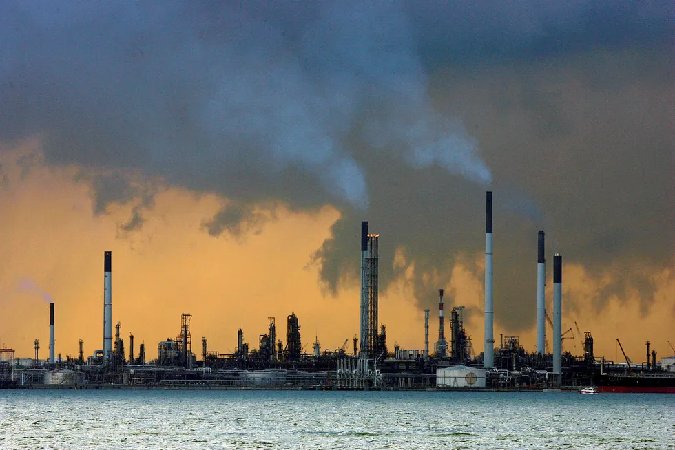 Røyk stiger ut av pipene fra et oljeraffineri ved kysten i Singapore.
