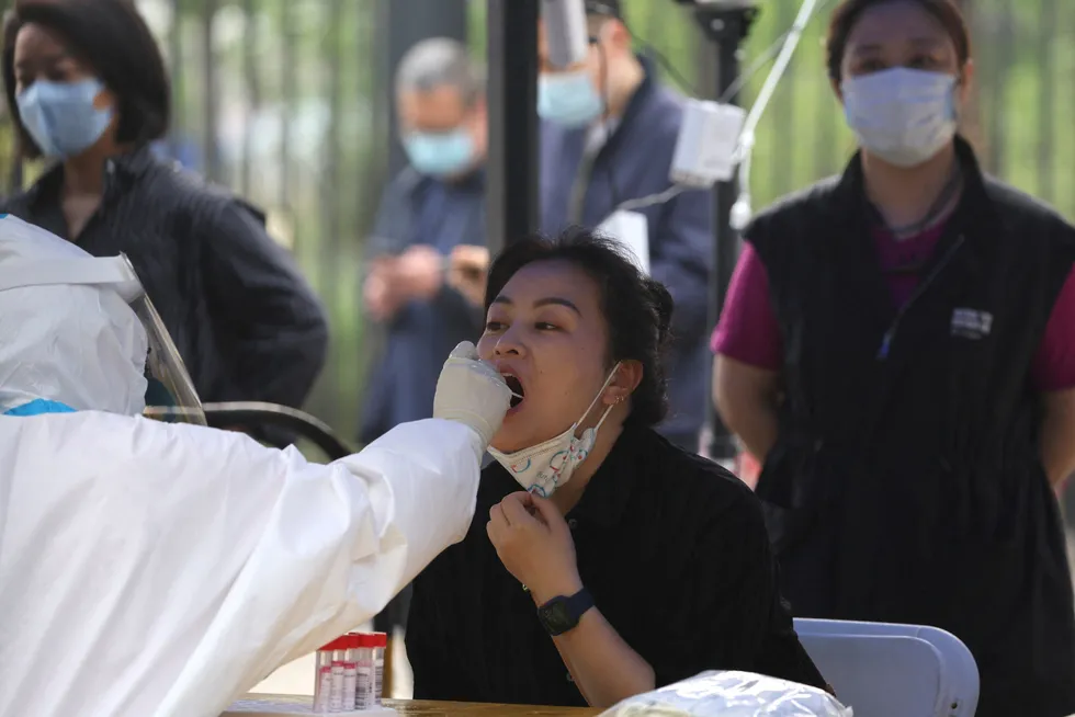 Testing: a medical worker takes a swab from a person during mass testing for Covid-19 following the outbreak in Beijing