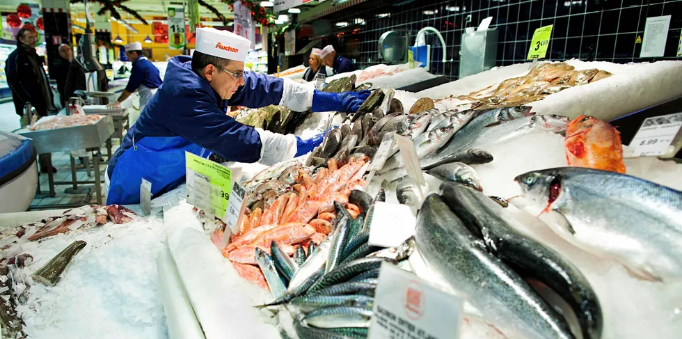 A worker prepares a display of seafood at French retail giant Carrefour. Buyers are pushing back on fresh farmed salmon prices this week after a spike in late February.