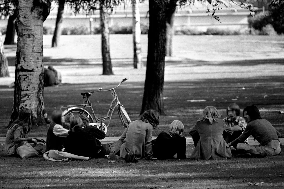 Samfunnspanikken satte inn i Norge i 1967. Eksempler på den moralske oppløsningen kunne være pornografi, kvinnefrigjøring, langt hår på menn, ungdommens hang til piggtrådmusikk og motstand mot Vietnamkrigen. Og selvsagt cannabisrøyking, skriver artikkelforfatteren. Her sitter en gruppe langhårede ungdommer i Slottsparken i Oslo i 1969. Foto: NTB Scanpix
