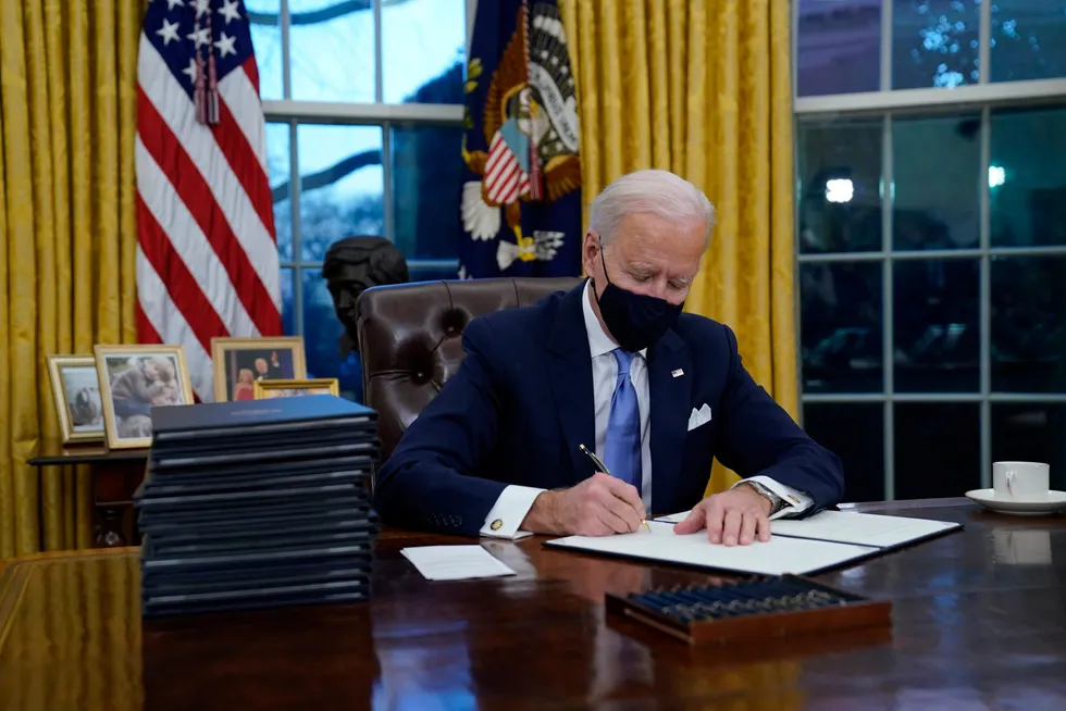 New beginning: US President Joe Biden signs his first of 15 executive orders in the Oval Office of the White House