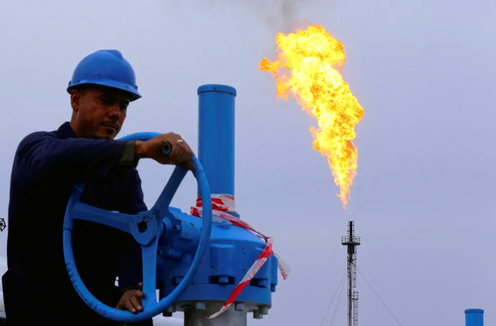 Flaring: a worker adjusts the valve of an oil pipe at the Khurmala oilfield on the outskirts of the city of Arbil, in Iraq's Kurdistan region