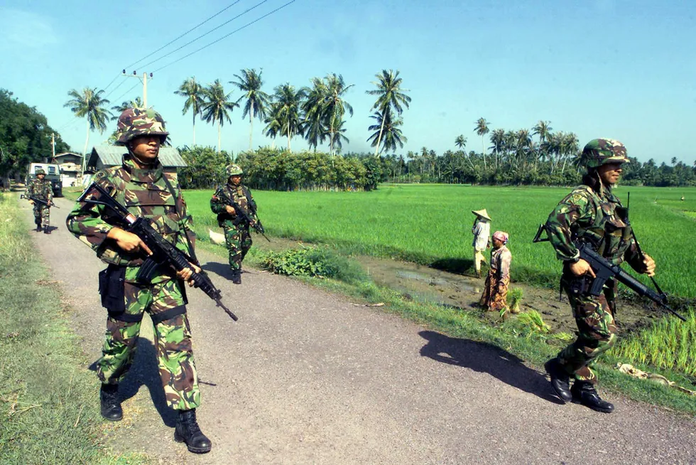 On patrol: Indonesian soldiers walk by rice fields in Aceh province in 2004.