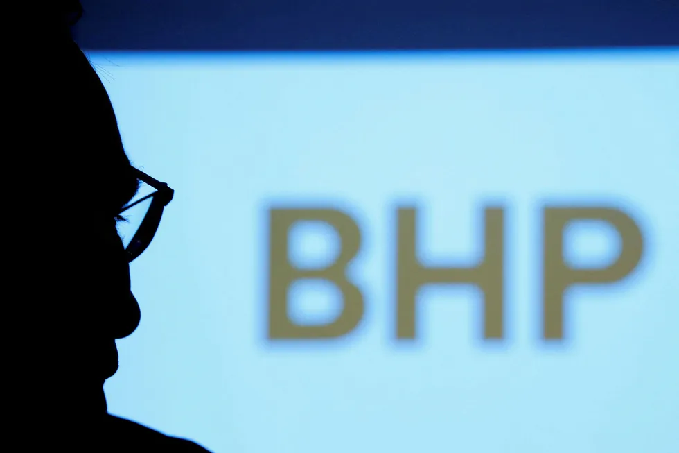 Commitment: a BHP executive is silhouetted against a screen projecting the company's logo