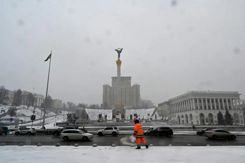 Preparing the road: a communal worker spreads salt on a sidewalk in the center of the Ukrainian capital of Kiev