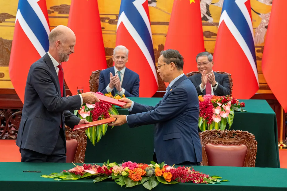 Norges ambassadør til Kina Vebjørn Dysvik, statsminister Jonas Gahr Støre og Kinas statsminister Li Qiang signerer en felles klimaavtale i Folkets store sal i Beijing tirsdag.