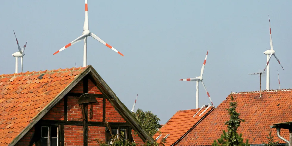 Wind turbines behind roofs in Dardesheim, eastern Germany