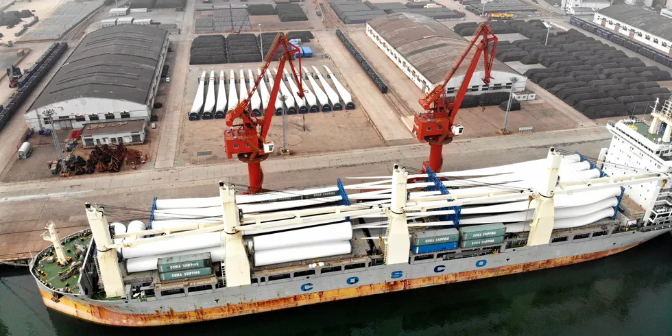 Aerial view of wind turbine blades which will be shipped abroad sitting stacked at a container ship berthed at Lianyungang Port, China.
