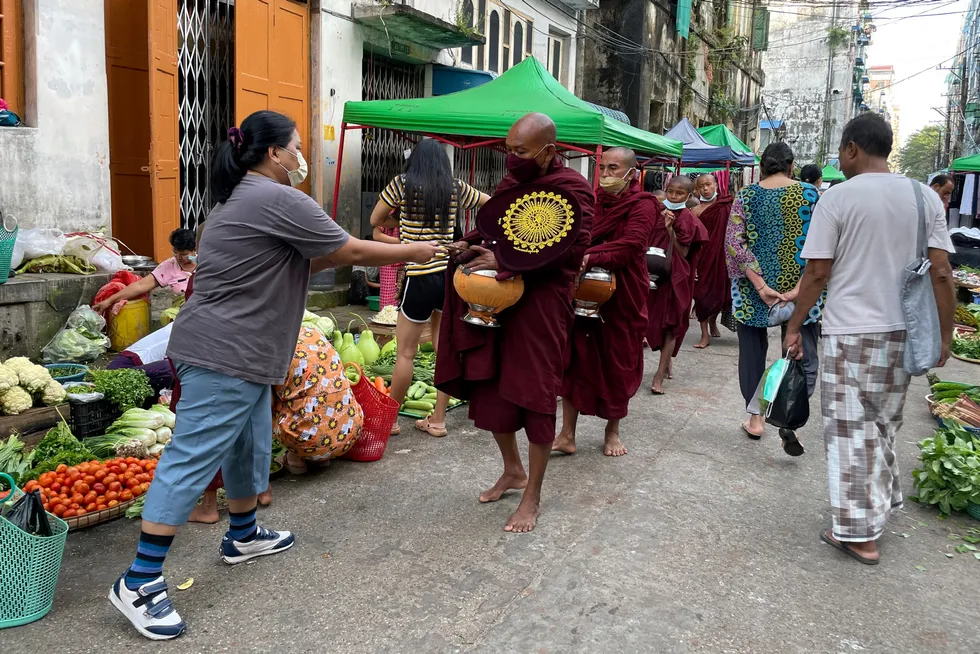 Tradition: Buddhist monks collect alms from people during their morning walk at Bogalay Zay Market in Botahtaung township in Yangon, Myanmar