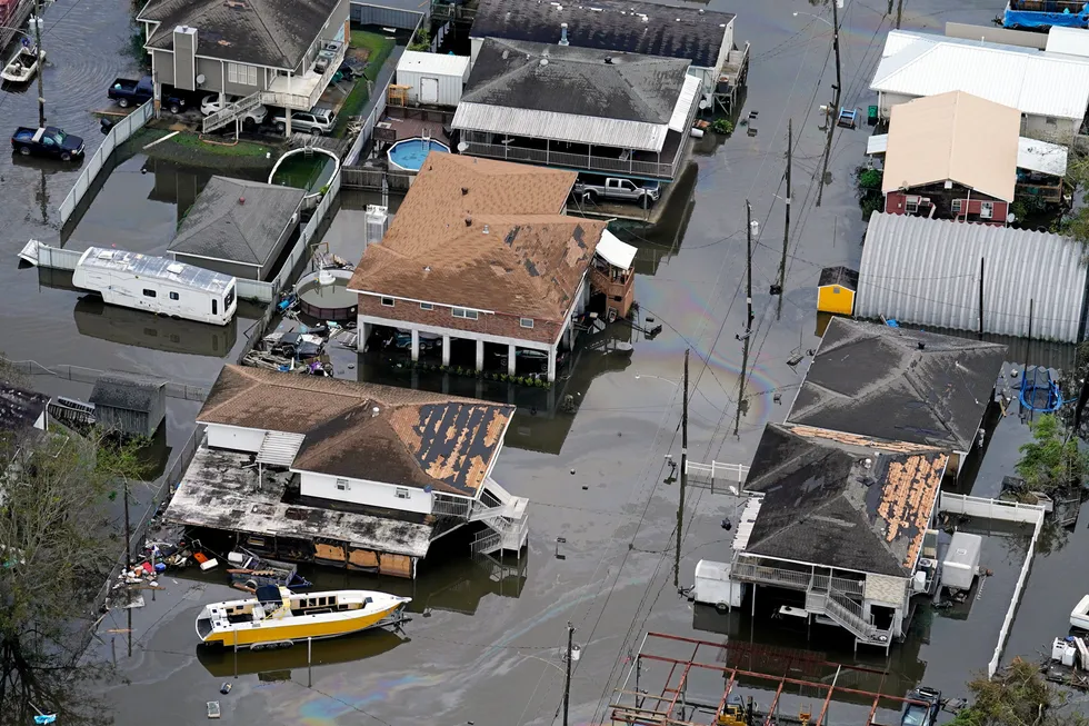 An oil slick drifts between damaged homes in the aftermath of Hurricane Ida in Lafitte, Louisianna