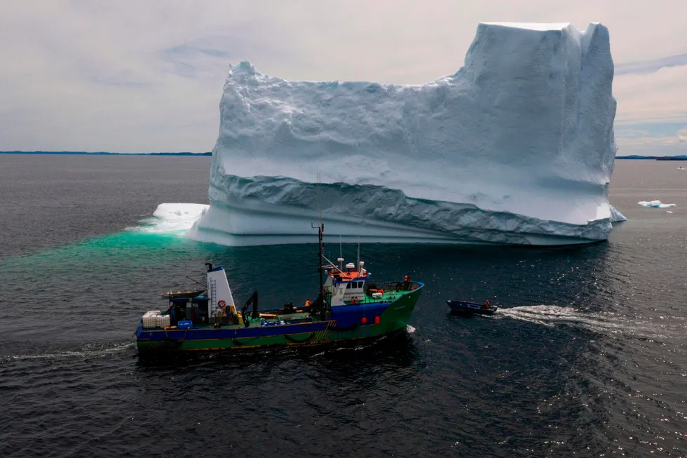 Iceberg alley: The Captain Edward Kean vessel passing an Iceberg in Bonavista Bay offshore Newfoundland in Canada.