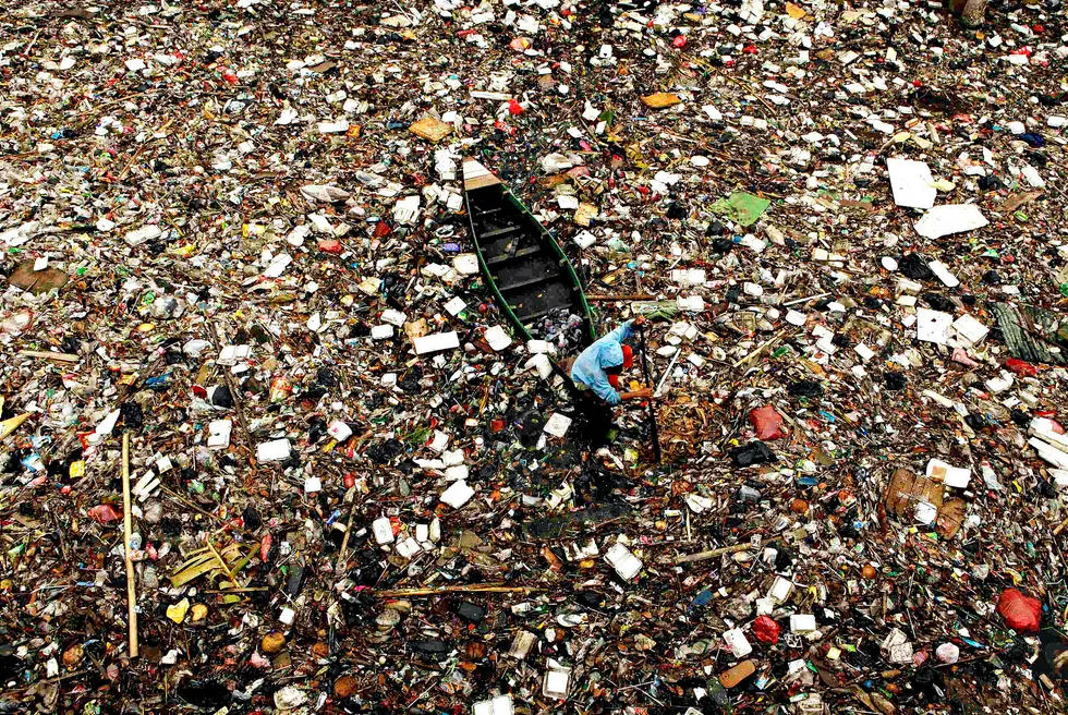 Plasthav. En mann samler plast for gjenvinning i en elv av søppel i nærheten av demningen i Pluit, Jakarta. Bildet er tatt i 2009. Foto: Beawiharta/Reuters/NTB scanpix