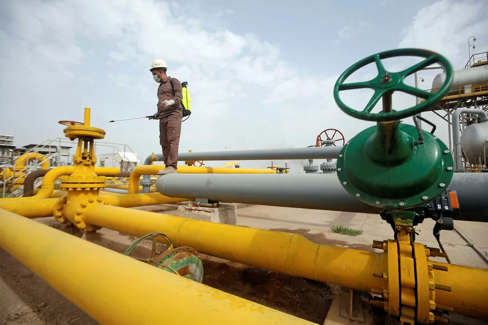 Iraq oil: Worker sprays disinfectant on valves in Basra region