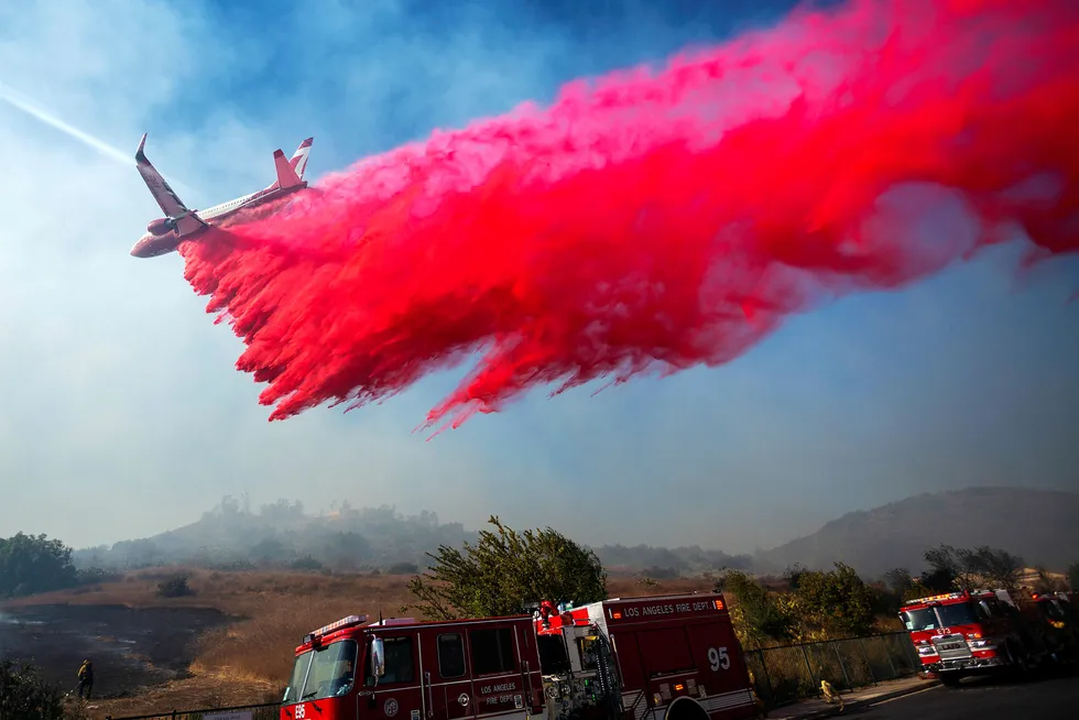 Et brannfly bistår mannskapene på bakken i kampen mot en brann nær Simi Valley i California i slutten av oktober. Kombinasjonen sterk vind og ekstrem tørke gjorde slukkearbeidet svært vanskelig.