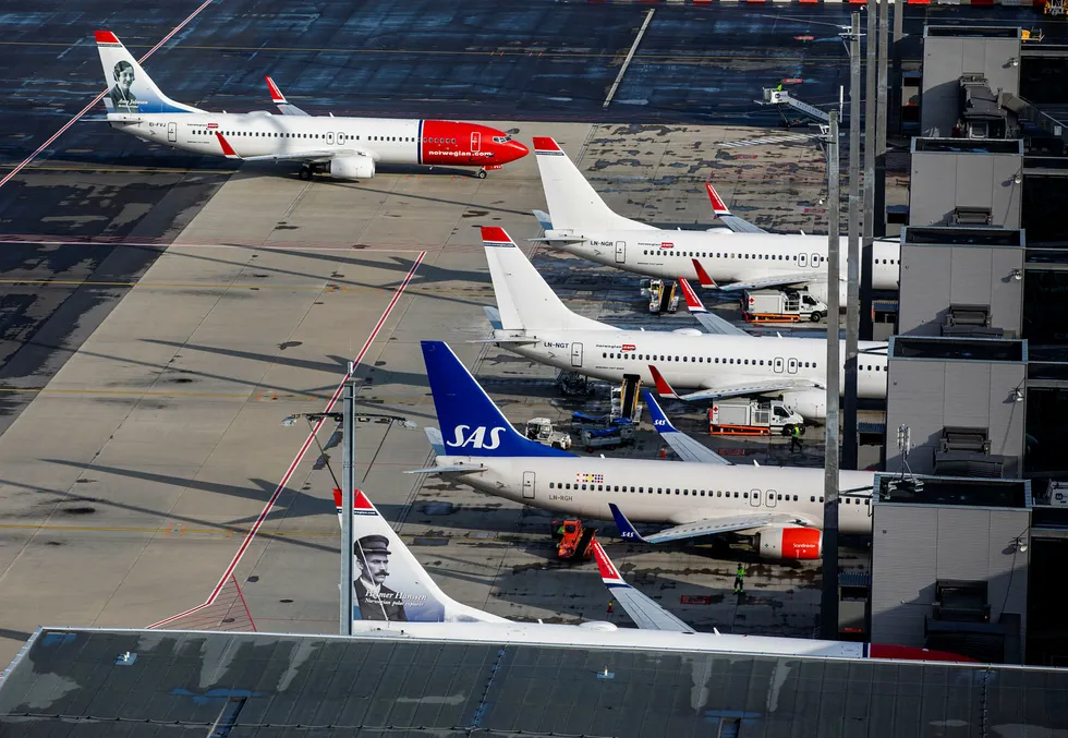 Norwegian og SAS fly står parkert på Oslo lufthavn.